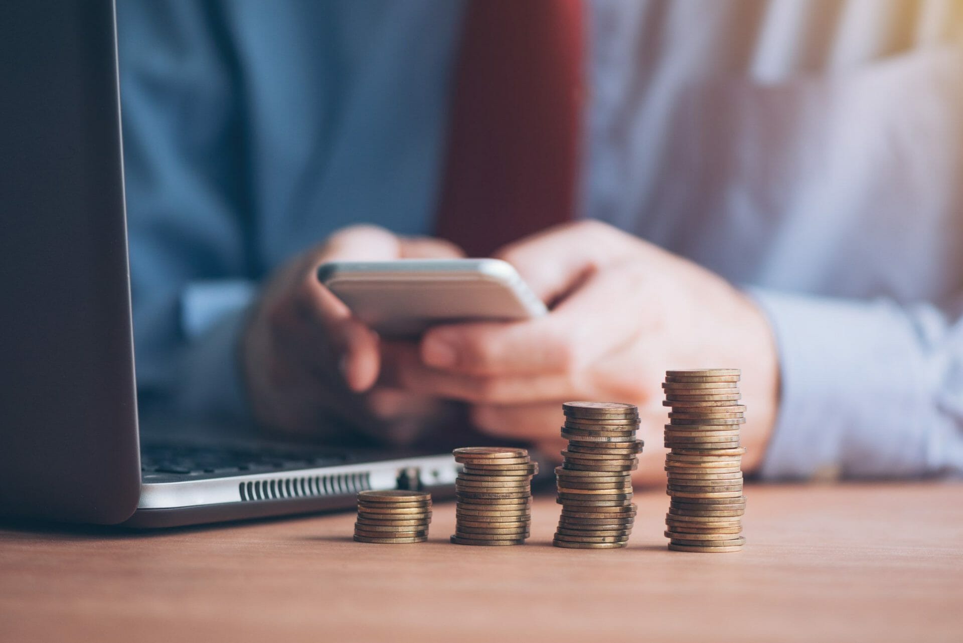 businessman phone coins stacked