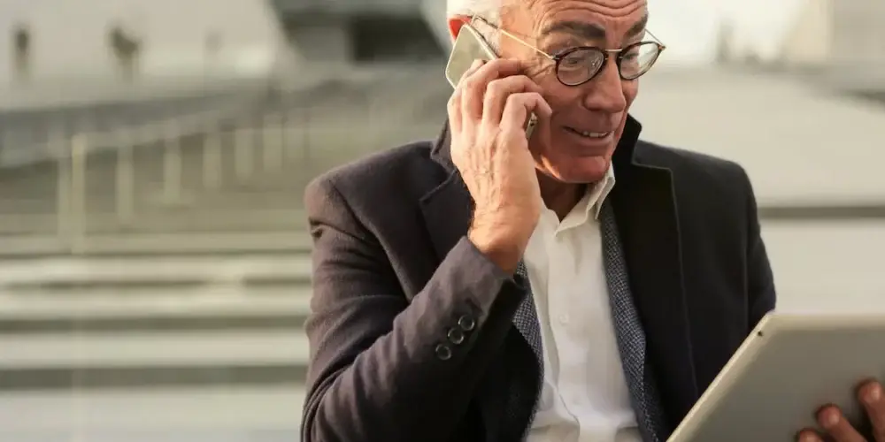 Man In Black Suit Holding A Mobile