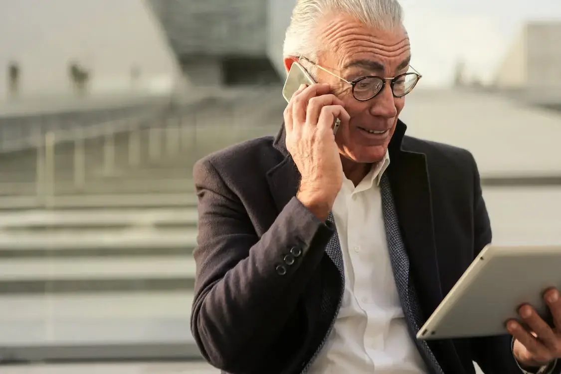 Man In Black Suit Holding A Mobile