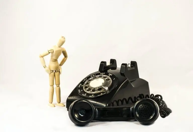 black rotary telephone beside beige manekin