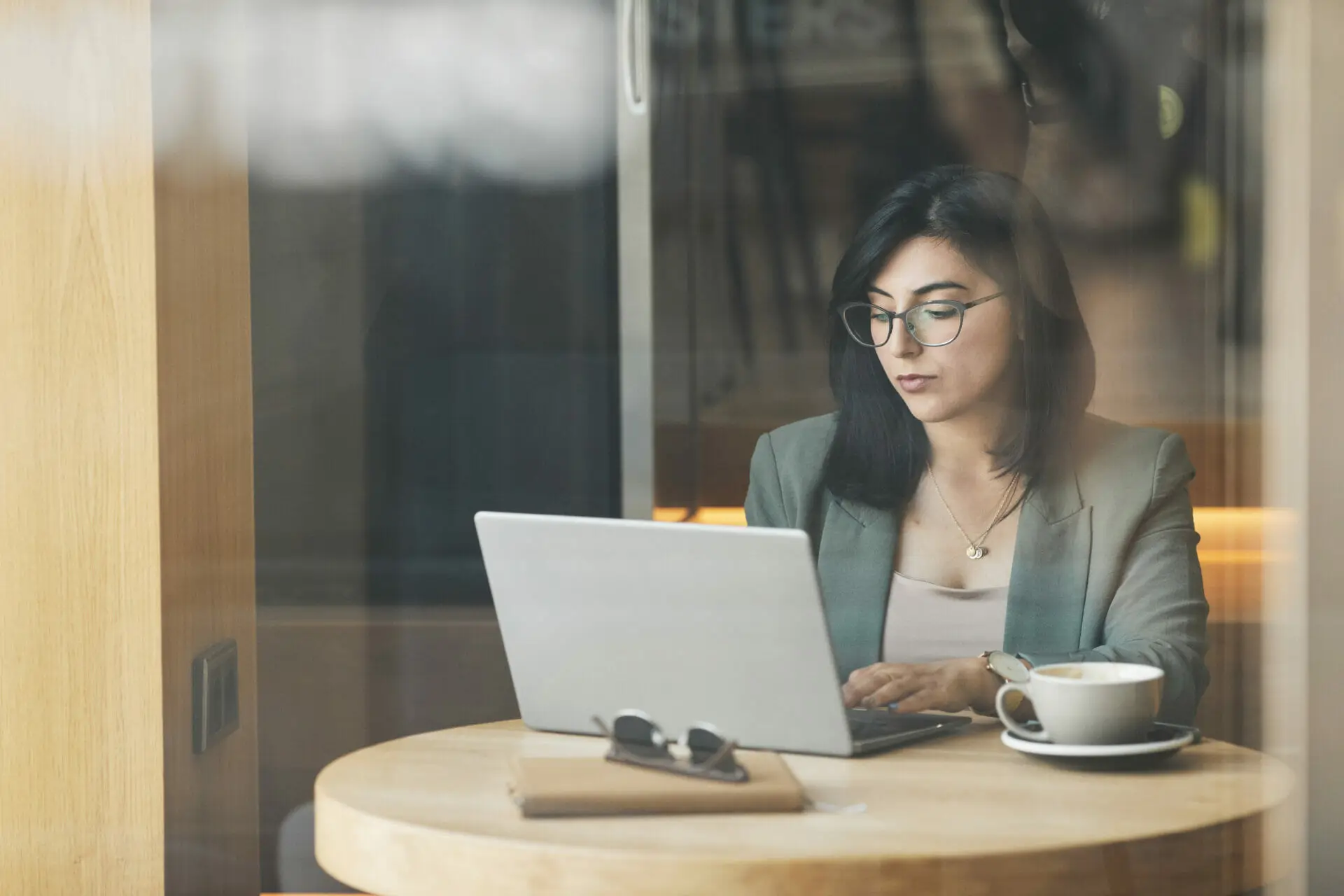 Portrait of successful businesswoman using laptop in cafe while working remotely